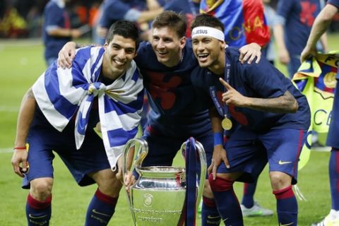Barcelona's Lionel Messi, centre, Neymar and Luis Suarez, left, celebrate with the trophy after after the Champions League final soccer match between Juventus Turin and FC Barcelona at the Olympic stadium in Berlin Saturday, June 6, 2015. Barcelona won the match 3-1.  (AP Photo/Frank Augstein)