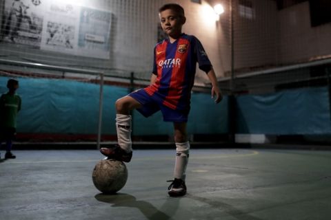 In this Nov. 11, 2016 photo, Benjamin Palandella poses for a portrait wearing his Barcelona shirt after a training session in Buenos Aires, Argentina. Palandella's coach Ramon Maddoni said "Benjamin is different from the group. He can pass with his back turned, he uses both legs." (AP Photo/Natacha Pisarenko)