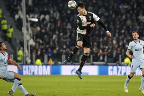 Atletico Madrid's Marcos Llorente, left, watches Juventus' Cristiano Ronaldo jumping for the ball during the Champions League group D soccer match between Juventus and Atletico Madrid at the Allianz stadium in Turin, Italy, Tuesday, Nov. 26, 2019. (AP Photo/Antonio Calanni)