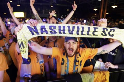 Soccer fans celebrate as the name of Nashville's MLS team, Nashville Soccer Club, is announced during the unveiling of the team name, logo and colors Wednesday, Feb. 20, 2019, in Nashville, Tenn. The expansion franchise is due to start play in 2020. (AP Photo/Mark Humphrey)