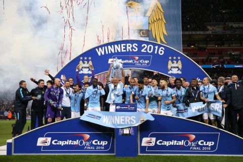 Manchester City's Vincent Kompany raises the trophy after winning the English League Cup final soccer match between Liverpool and Manchester City at Wembley stadium in London, Sunday, Feb. 28, 2016. (Sharon Latham/Pool via AP)
