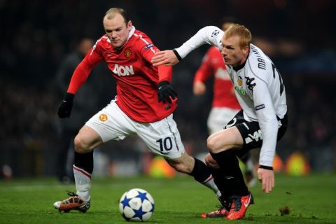 MANCHESTER, ENGLAND - DECEMBER 07:  Jeremy Mathieu of Valencia challenges Wayne Rooney of Manchester United during the UEFA Champions League Group C match between Manchester United and Valencia at Old Trafford on December 7, 2010 in Manchester, England.  (Photo by Clive Mason/Getty Images)