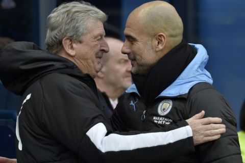 Manchester City's head coach Pep Guardiola, right, speaks with Crystal Palace's manager Roy Hodgson prior the English Premier League soccer match between Manchester City and Crystal Palace at Etihad stadium in Manchester, England, Saturday, Jan. 18, 2020. (AP Photo/Rui Vieira)