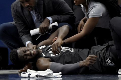 Brooklyn Nets guard Caris LeVert (22) is tended to after an injury during the second quarter of an NBA basketball game against the Minnesota Timberwolves on Monday, Nov. 12, 2018, in Minneapolis. (AP Photo/Hannah Foslien)