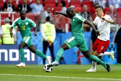 Senegal's Kalidou Koulibaly, center, and Poland's Robert Lewandowski compete for the ball during the group H match between Poland and Senegal at the 2018 soccer World Cup in the Spartak Stadium in Moscow, Russia, Tuesday, June 19, 2018. (AP Photo/Eduardo Verdugo)