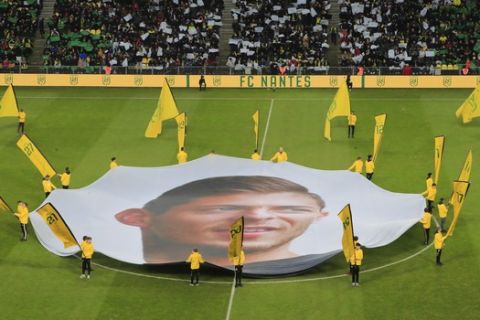 A giant canvas showing late Argentinian player Emiliano Sala is pictured in La Beaujoire stadium prior the French League One soccer match between Nantes against Bordeaux in Nantes, western France, Sunday, Jan. 26, 2020. Nantes paid an emotional tribute to Emiliano Sala by wearing a special blue and white (AP Photo/Michel Euler)
