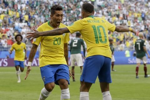 Brazil's Roberto Firmino, left, celebrates with Brazil's Neymar, right, after scoring his side's second goal during the round of 16 match between Brazil and Mexico at the 2018 soccer World Cup in the Samara Arena, in Samara, Russia, Monday, July 2, 2018. (AP Photo/Andre Penner)