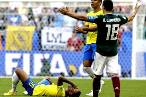 Brazil's Neymar, left, lies on the ground as Mexico's Andres Guardado, right, gestures during the round of 16 match between Brazil and Mexico at the 2018 soccer World Cup in the Samara Arena, in Samara, Russia, Monday, July 2, 2018. (AP Photo/Andre Penner)