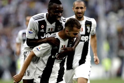 Juventus' Miralem Pjanic, bottom, celebrates with teammate Juventus' Blaise Matuidi after scoring the opening goal of the game during the Serie A soccer match between Juventus and Lazio at the Allianz Stadium in Turin, Italy, Saturday, Aug. 25, 2018. (AP Photo/Luca Bruno)