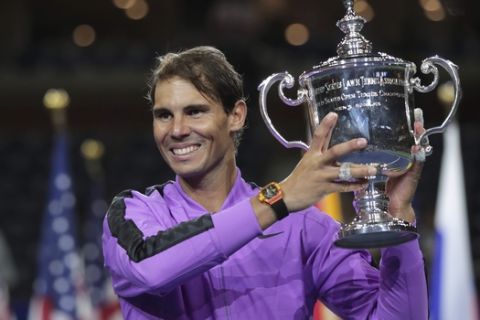 Rafael Nadal, of Spain, holds up the championship trophy after defeating Daniil Medvedev, of Russia, to win the men's singles final of the U.S. Open tennis championships Sunday, Sept. 8, 2019, in New York. (AP Photo/Charles Krupa)