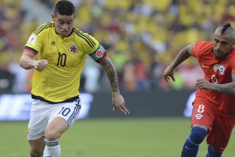 Colombia's James Rodriguez, left, and Chile's Arturo Vidal chase the ball in a 2018 World Cup qualifying soccer match in Barranquilla, Colombia, Thursday, Nov. 10, 2016. (AP Photo/Luis Benavides)
