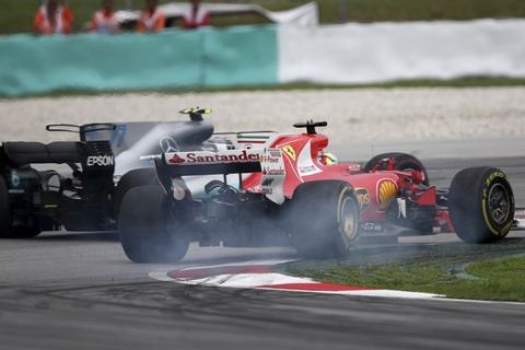 Ferrari driver Sebastian Vettel of Germany, right, brakes as he attempts to pass Mercedes driver Valtteri Bottas of Finland during the Malaysian Formula One Grand Prix in Sepang International Circuit in Sepang, Malaysia, Sunday, Oct. 01, 2017. (AP Photo/Daniel Chan)