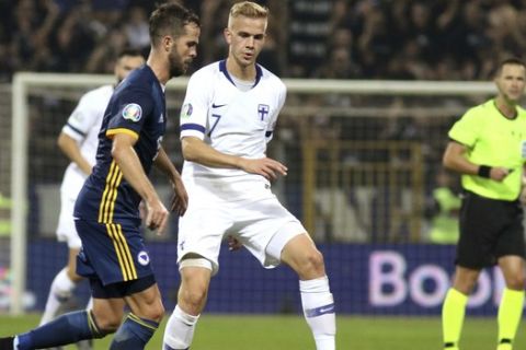 Bosnia's Miralem Pjanic, left, duels for the ball with Finland's Jasse Tuominen during the Euro 2020 group J qualifying soccer match between Bosnia-Herzegovina and Finland at the Bilino polje stadium in Zenica, Bosnia, Saturday, Oct. 12, 2019. (AP Photo/Kemal Softic)