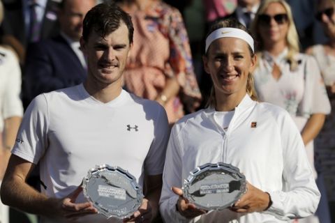 Britain's Jamie Murray, left, and Victoria Azarenka of Belarus hold their runner-up trophies after losing to Nicole Melichar of the United States and Austria's Alexander Peya, in the mixed doubles final match, at the Wimbledon Tennis Championships, in London, Sunday July 15, 2018.(AP Photo/Ben Curtis)