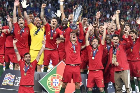 Portugal's Cristiano Ronaldo lifts up the trophy as he celebrates with players after winning the UEFA Nations League final soccer match between Portugal and Netherlands at the Dragao stadium in Porto, Portugal, Sunday, June 9, 2019. Portugal won 1-0. (AP Photo/Martin Meissner)