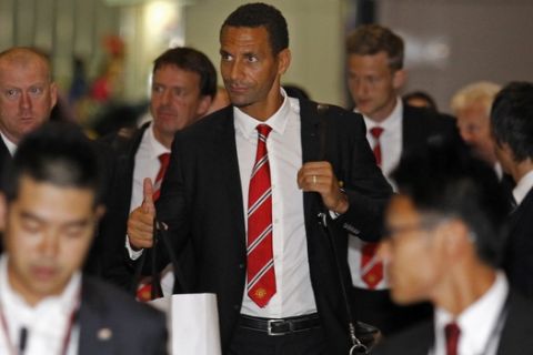 Manchester United player Rio Ferdinand, center, and teammates arrive at Narita international airport in Narita, east of Tokyo, early Monday, July 22, 2013. England's Premier League soccer team is in Japan for the third stop of its preseason Asia Pacific tour for friendly matches against Yokohama F Marinos and Cerezo Osaka. (AP Photo/Shuji Kajiyama)