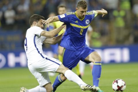 Bosnia's Edin Dzeko, right, duels for the ball with Greece's Sokratis Papastathopoulos, during their World Cup Group H qualifying match at the Bilino Polje Stadium in Zenica on Friday, June 9, 2017. (AP Photo/Amel Emric)