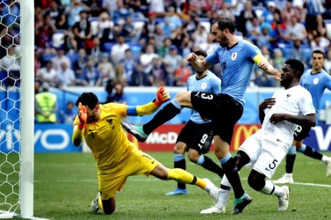 France goalkeeper Hugo Lloris, left, saves a shot by Uruguay's Diego Godin, front, during the quarterfinal match between Uruguay and France at the 2018 soccer World Cup in the Nizhny Novgorod Stadium, in Nizhny Novgorod, Russia, Friday, July 6, 2018. (AP Photo/David Vincent)