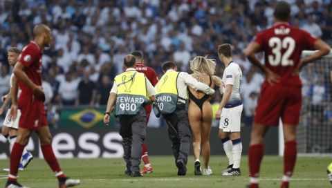 A pitch invader is lead off the field by security during the Champions League final soccer match between Tottenham Hotspur and Liverpool at the Wanda Metropolitano Stadium in Madrid, Saturday, June 1, 2019. (AP Photo/Bernat Armangue)