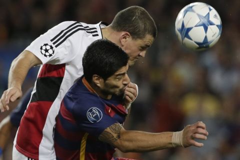 Leverkusen's Kyriakos Papadopoulos, left, fights for the ball with Barcelona's Luis Suarez during a Champions League Group E soccer match between Barcelona and Bayer Leverkusen at Camp Nou stadium in Barcelona, Spain, Tuesday, Sept. 29, 2015. (AP Photo/Emilio Morenatti)