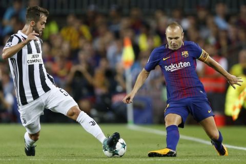 Juventus' Miralem Pjanic, left, intercepts a pass for Barcelona's Andres Iniesta during a Champions League group D soccer match between FC Barcelona and Juventus at the Camp Nou stadium in Barcelona, Spain, Tuesday, Sept. 12, 2017. (AP Photo/Francisco Seco)