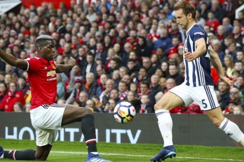 Manchester United's Paul Pogba, left, and West Bromwich Albion's Claudio Yacob battle for the ball during the English Premier League soccer match at Old Trafford, Manchester, England, Sunday April 15, 2018. (Nick Potts/PA via AP)