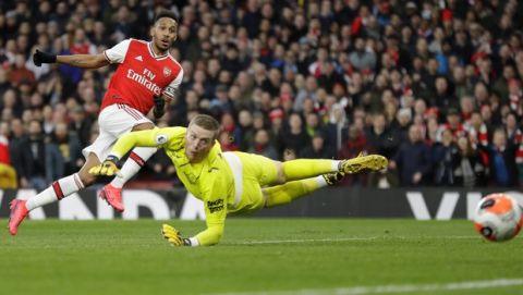 Arsenal's Pierre-Emerick Aubameyang, left, scores his side's second goal as Everton's goalkeeper Jordan Pickford fails to save the ball during the English Premier League soccer match between Arsenal and Everton at Emirates stadium in London, Sunday, Feb. 23, 2020. (AP Photo/Kirsty Wigglesworth)