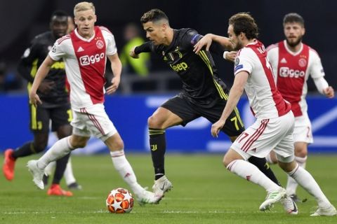 Juventus' Cristiano Ronaldo, center, is challenged for the ball with Ajax's Daley Blind, right, and Ajax's Donny van de Beek during the Champions League quarterfinal, first leg, soccer match between Ajax and Juventus at the Johan Cruyff ArenA in Amsterdam, Netherlands, Wednesday, April 10, 2019. (AP Photo/Martin Meissner)
