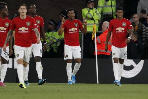 Manchester United's Anthony Martial, center, celebrates with teammates after scoring his side's opening goal during the English Premier League soccer match between Wolverhampton Wanderers and Manchester United at the Molineux Stadium in Wolverhampton, England, Monday, Aug. 19, 2019. (AP Photo/Rui Vieira)