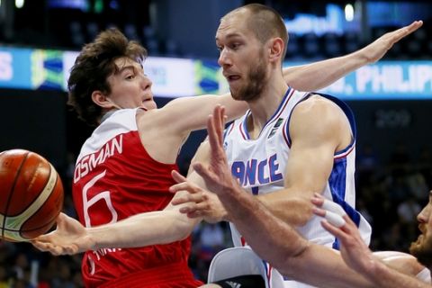 Kim Tillie, center, of France drives through the defense of Turkey's Cedi Osman (6) and Semih Erden during their semi-final match in the FIBA Olympic Qualifying basketball Saturday, July 9, 2016 in suburban Pasay city south of Manila, Philippines. France won 75-63 to face Canada in the finals. At left is Turkey's Sinan Guler.(AP Photo/Bullit Marquez)