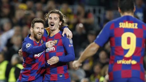 Barcelona's Lionel Messi, left, celebrates after scoring his side's second goal with Antoine Griezmann, centre and Luis Suarez during a Champions League soccer match Group F between Barcelona and Dortmund at the Camp Nou stadium in Barcelona, Spain, Wednesday, Nov. 27, 2019. (AP Photo/Joan Monfort)