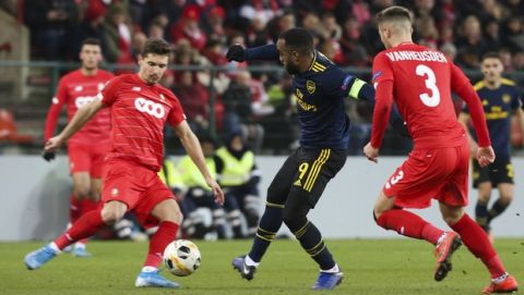 Arsenal's Alexandre Lacazette, center, fights for the ball with Liege's Gojko Cimirot, left, during a Europa League group F soccer match between Standard Liege and Arsenal at the Maurice Dufrasne stadium in Liege, Belgium, Thursday, Dec, 12, 2019. Lacazette scored once and the match ended in a 2-2 draw. (AP Photo/Francois Walschaerts)