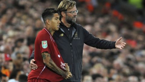 Liverpool manager Juergen Klopp, right, gives instructions to Roberto Firmino during the English League Cup soccer match between Liverpool and Chelsea at Anfield stadium in Liverpool, England, Wednesday, Sept. 26, 2018. (AP Photo/Rui Vieira)