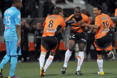 Lorient's defender Lamine Kone (2ndR) jubilates with teammates after scoring a goal during their French L1 football match Lorient vs. Marseille on May 15, 2011 in the French western city of Lorient. AFP PHOTO FRANK PERRYFrench (Photo credit should read FRANK PERRY/AFP/Getty Images)