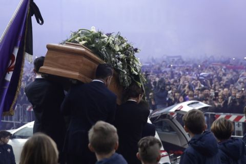 The coffin leaves the church in a purple smoke screen at the end of the funeral ceremony of Italian player Davide Astori in Florence, Italy, Thursday, March 8, 2018. The 31-year-old Astori was found dead in his hotel room on Sunday after a suspected cardiac arrest before his team was set to play an Italian league match at Udinese. (AP Photo/Alessandra Tarantino)