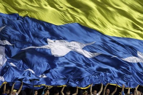 Bosnia supporters wave a large big flag as they celebrate their victory over Israel in their Euro 2016 Group B qualifying soccer match in Zenica, Bosnia, Friday June 12, 2015. (AP Photo/Amel Emric)