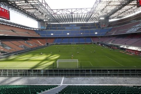 FILE - In this Sunday, March 8, 2020 file photo, a view of the empty San Siro stadium during the Serie A soccer match between AC Milan and Genoa, in Milan, Italy. The Italian soccer players' association rejected a proposal from Serie A clubs Monday to reduce salaries by a third if the season does not resume as "unmanageable." The guideline austerity measure was agreed on by 19 of the 20 clubs, the Italian league announced, with Juventus not included because it already finalized a deal with its players to relieve financial pressure on the eight-time defending champion amid the coronavirus pandemic. (AP Photo/Antonio Calanni, File)