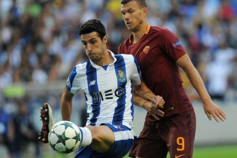 Porto's Ivan Marcano, left, controls the ball in front of Roma's Edin Dzeko during a Champions League play-offs first leg soccer match between FC Porto and AS Roma at the Dragao stadium in Porto, Portugal, Wednesday, Aug. 17, 2016. (AP Photo/Paulo Duarte)