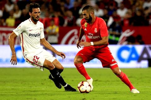 Real Madrid's Karim Benzema, right, and Sevilla's Franco Vazquez, fight for the ball during La Liga soccer match between Sevilla and Real Madrid at the Sanchez Pizjuan stadium, in Seville, Spain on Wednesday, Sept.. 26, 2018. (AP Photo/Miguel Morenatti)