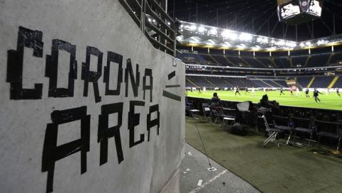 FILE - In this Thursday, March 12, 2020 file photo shows a sign taped by Eintracht fans on a wall of the stadium during a Europa League round of 16, 1st leg soccer match between Eintracht Frankfurt and FC Basel in Frankfurt, Germany. (AP Photo/Michael Probst)