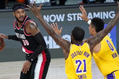 Portland Trail Blazers' Carmelo Anthony (00) looks for a way past Los Angeles Lakers' JR Smith (21) and Kyle Kuzma (0) during the first half of an NBA basketball first round playoff game Saturday, Aug. 29, 2020, in Lake Buena Vista, Fla. (AP Photo/Ashley Landis)