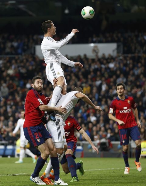 MADRID, SPAIN - JANUARY 09: Cristiano Ronaldo (Up) of Real Madrid jumps for the ball over Karim Benzema (R) and Damia Abella of Osasuna during the Copa del Rey round of 16 first leg match between Real Madrid and Osasuna at Estadio Santiago Bernabeu on January 9, 2014 in Madrid, Spain.  (Photo by Angel Martinez/Real Madrid via Getty Images)