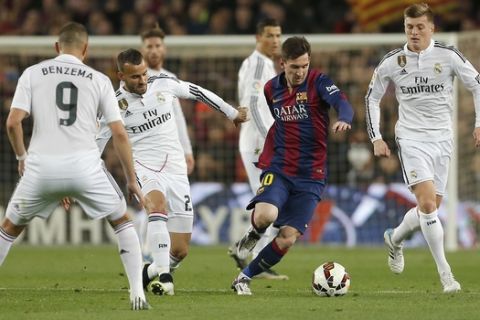 Real Madrid's Karim Benzema, left, Real Madrid's Raphel Varane, second left, Real Madrid's Toni Kroos, right, Real Madrid's Cristiano Ronaldo, rear center, and Real Madrid's goalkeeper Iker Casillas, left, watch as Barcelona's Lionel Messi, center, drybbles with the ball during a Spanish La Liga soccer match between FC Barcelona and Real Madrid at Camp Nou stadium, in Barcelona, Spain, Sunday, March 22, 2015. (AP Photo/Emilio Morenatti)