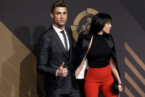 Real Madrid player Cristiano Ronaldo gestures as he arrives with his girlfriend Georgina Rodriguez for the Portuguese soccer federation awards ceremony Monday, March 19, 2018, in Lisbon. (AP Photo/Armando Franca)