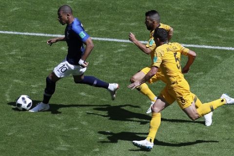 France's Kylian Mbappe, left, Australia's Mark Milligan, front right, and Australia's Aziz Behich run for the ball during the group C match between France and Australia at the 2018 soccer World Cup in the Kazan Arena in Kazan, Russia, Saturday, June 16, 2018. (AP Photo/Hassan Ammar)