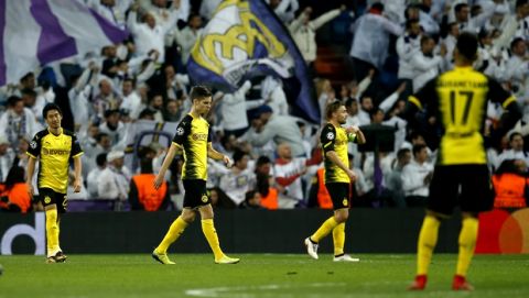 Dortmund's Shinji Kagawa, Marc Bartra, Marcel Schmelzer and Pierre-Emerick Aubameyang walks on the pitch disappointed after Real's third goal during the Champions League Group H soccer match between Real Madrid and Borussia Dortmund at the Santiago Bernabeu stadium in Madrid, Spain, Wednesday, Dec. 6, 2017. (AP Photo/Paul White)