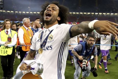 Real Madrid's Marcelo celebrates with the trophy after the Champions League Final soccer match between Juventus and Real Madrid at the Millennium Stadium in Cardiff, Wales, Saturday, June 3, 2017. (Nick Potts/PA via AP)