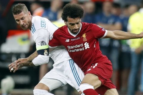 Real Madrid's Sergio Ramos, left, and Liverpool's Mohamed Salah challenge for the ball during the Champions League Final soccer match between Real Madrid and Liverpool at the Olimpiyskiy Stadium in Kiev, Ukraine, Saturday, May 26, 2018. (AP Photo/Efrem Lukatsky)