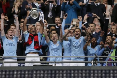 Manchester City's team captain Vincent Kompany lifts the trophy after winning the English FA Cup Final soccer match between Manchester City and Watford at Wembley stadium in London, Saturday, May 18, 2019. Manchester City won 6-0. (AP Photo/Tim Ireland)