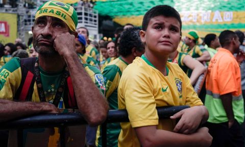 A young Brazil soccer fan, right, cries at the end of a live broadcast of the World Cup quarterfinal match between Brazil and Belgium in Rio de Janeiro, Brazil, Friday, July 6, 2018. Belgium knocked Brazil out of the World Cup and advanced to the semi-finals.  (AP Photo/Leo Correa)
